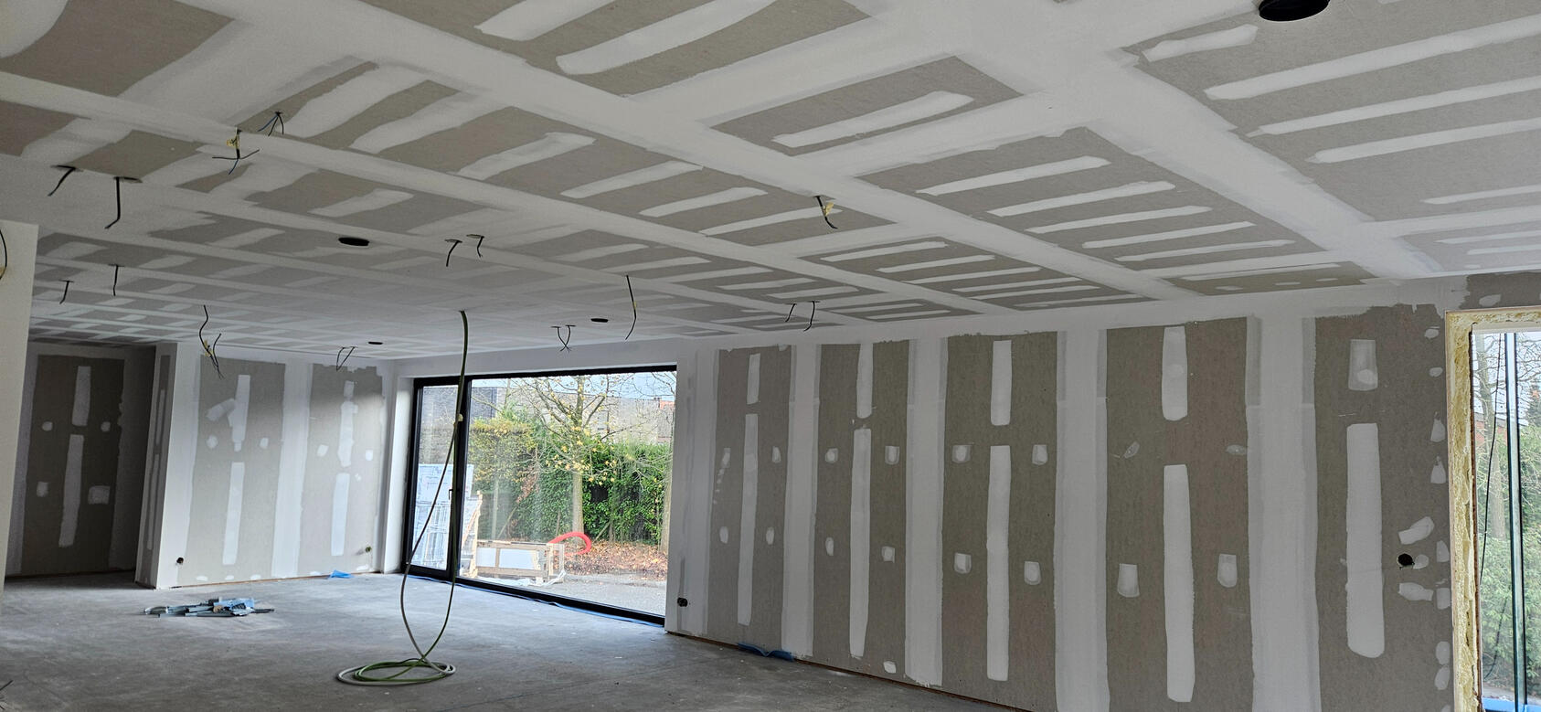Living room 200m² volledig afgewerkt — S GYPFIX Ingelmunster Groot plafond en wanden van 200m² living room volledig geplamuurd in Ingelmunster - S GYPFIX